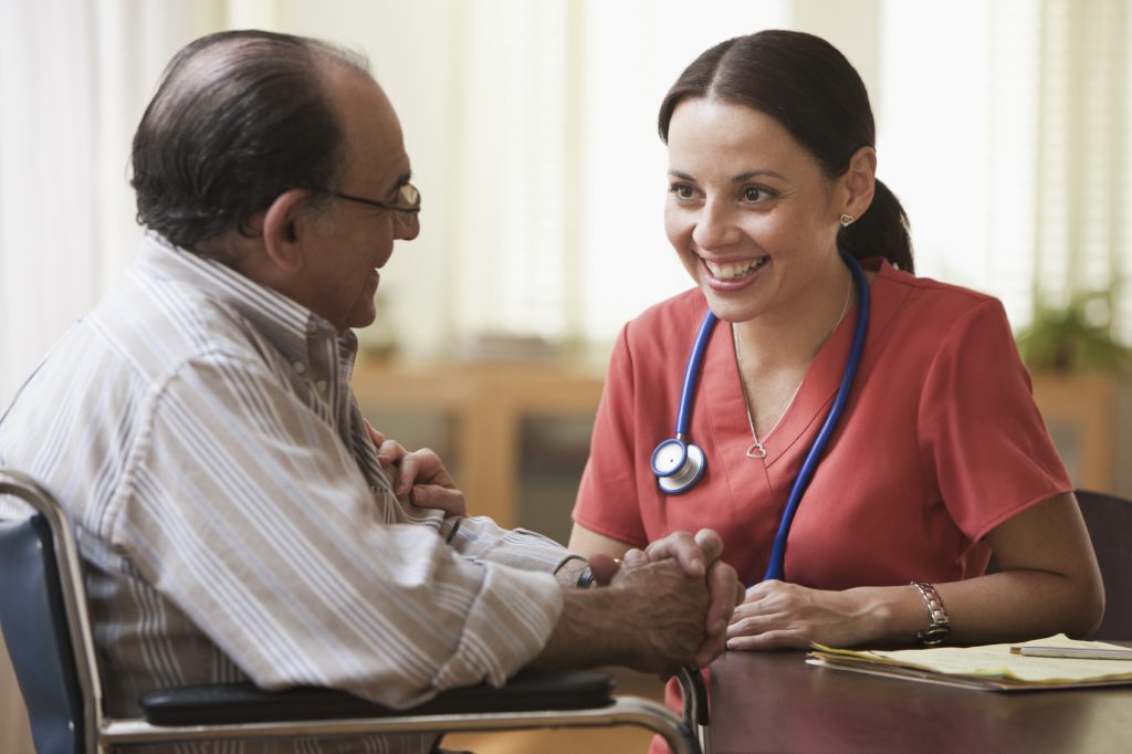 a medical professional talks to a patient in a wheelchair