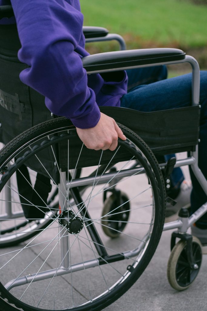 A person in a wheelchair, close up of their hands directing the wheels